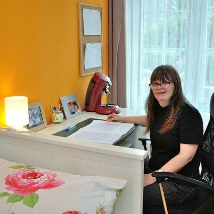 Bewohnerin der WG Burscheid am Schreibtisch in ihrem Zimmer
